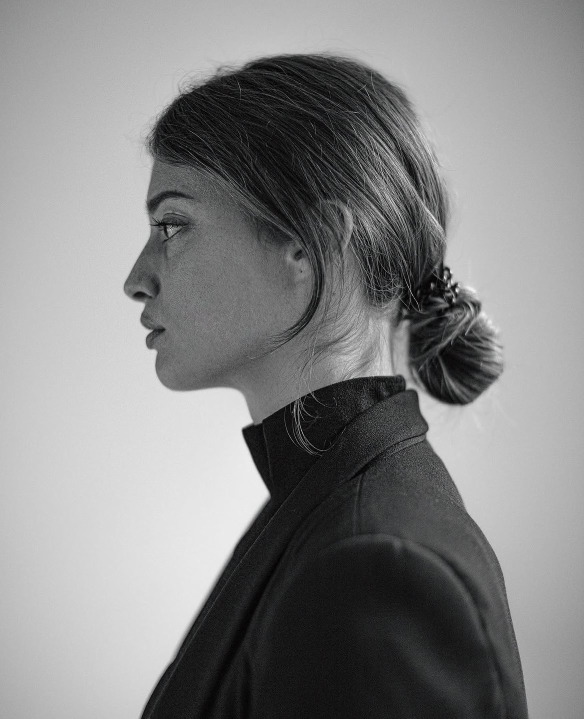 Black-and-white profile of a brunette with hair bun