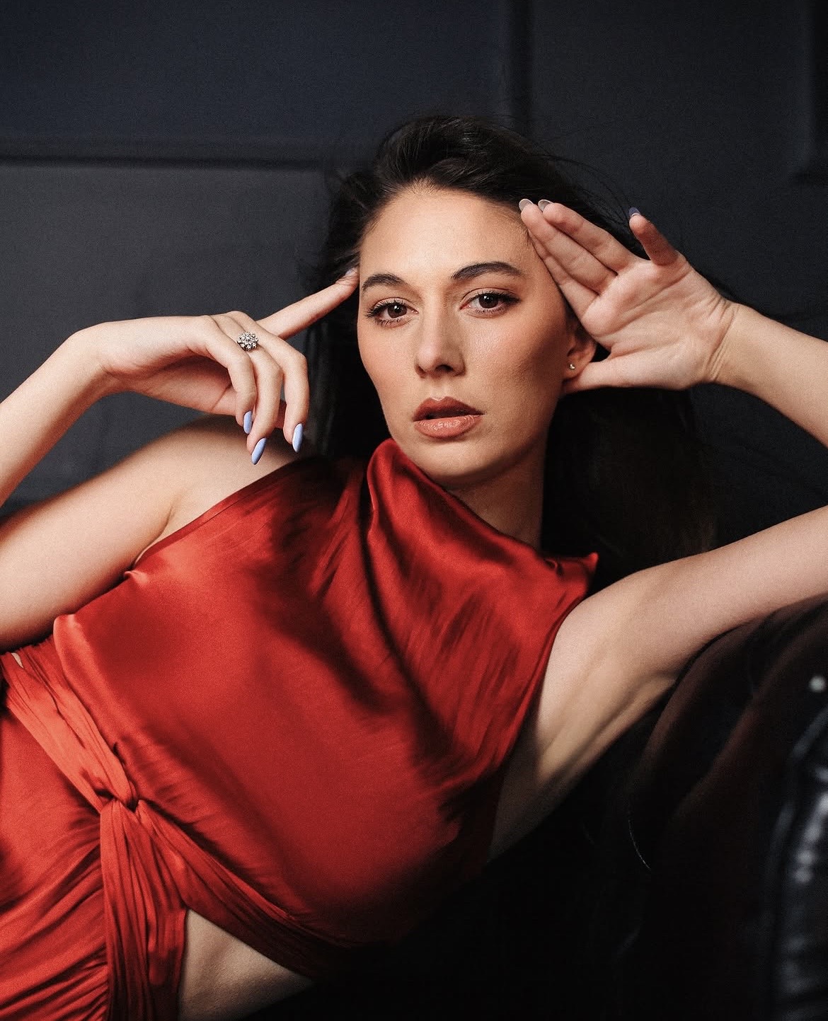 Brunette in red with hands near face
