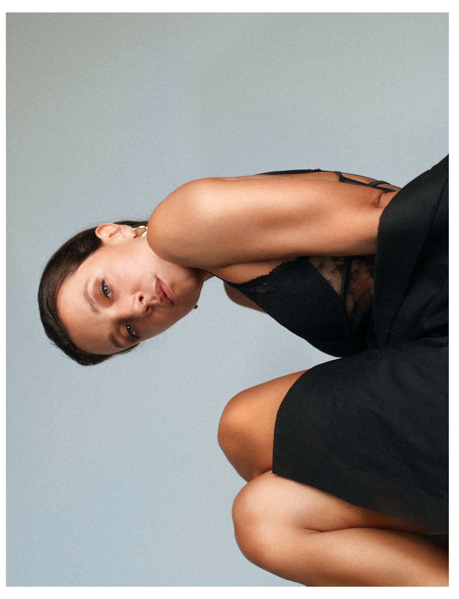 Reclining portrait in black lace against muted backdrop