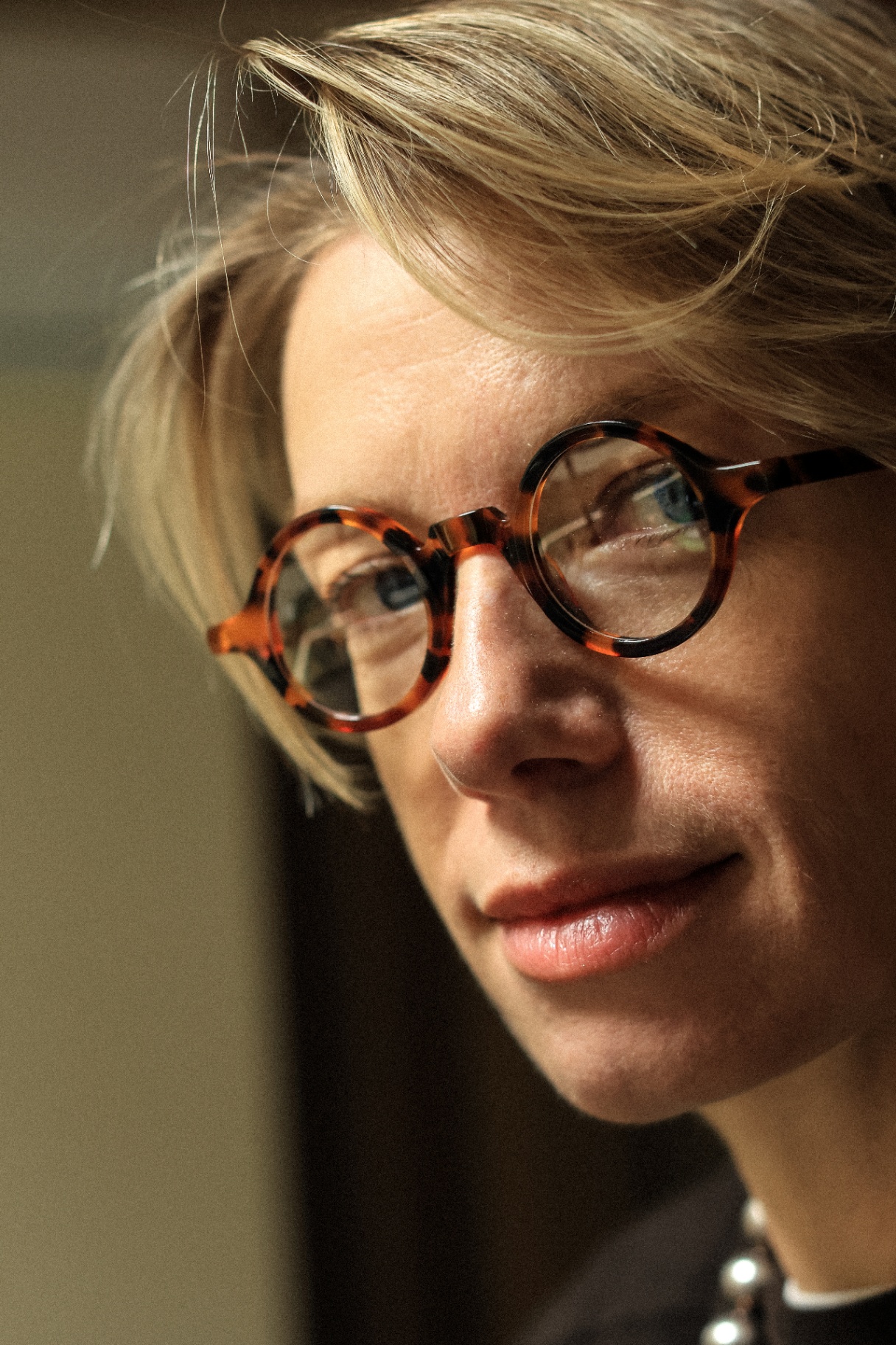 Close-up portrait of a blonde model with tortoiseshell glasses