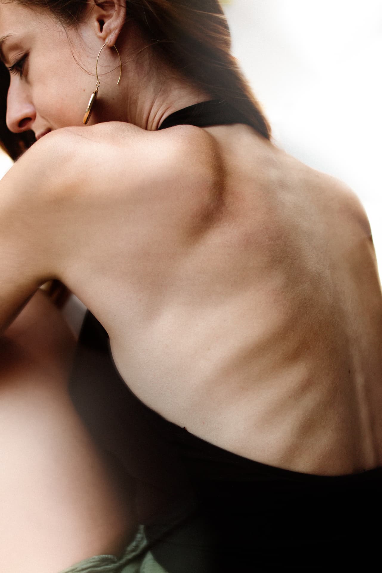 Backlit study of a bare shoulder and back