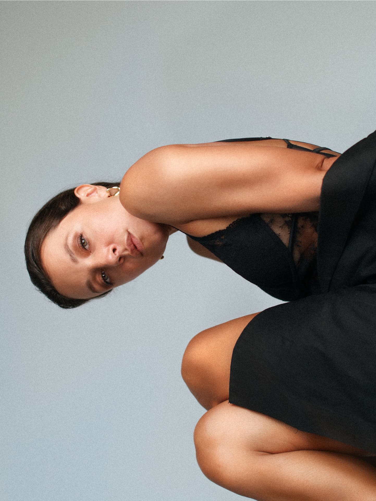 Reclining portrait in black lace against muted backdrop